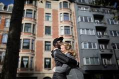 Un couple s'enlace devant un immeuble d'appartements à Bruxelles.